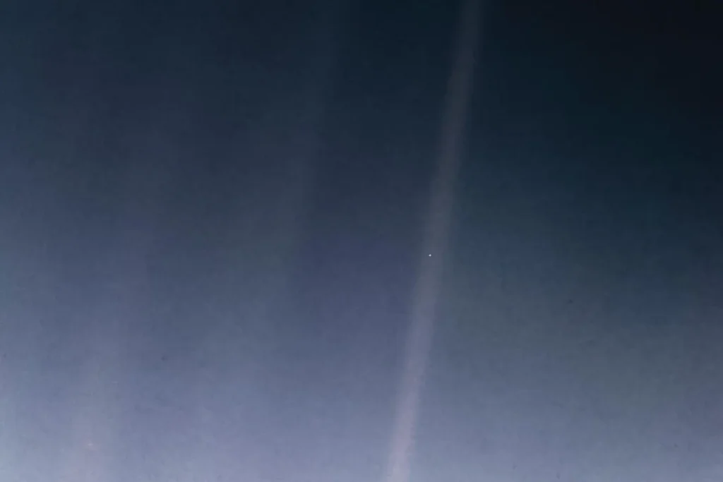 Pale Blue Dot: Earth as a tiny speck in a band of scattered sunlight, photographed by Voyager 1 from about 6 billion kilometres away