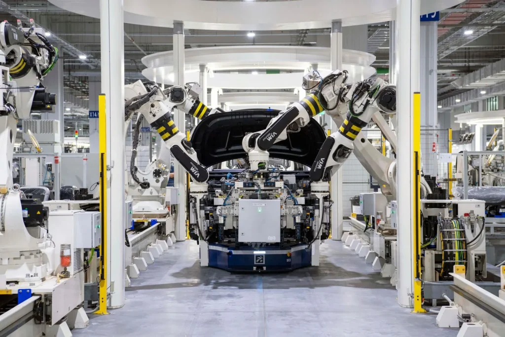 Industrial robot arms assembling a car on a modern factory production line