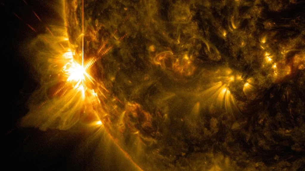 Close-up of the Sun's glowing surface with a bright solar flare erupting near its edge